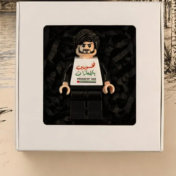 A mini figure in black wearing a Proud of UAE torso, boxed and ready to give