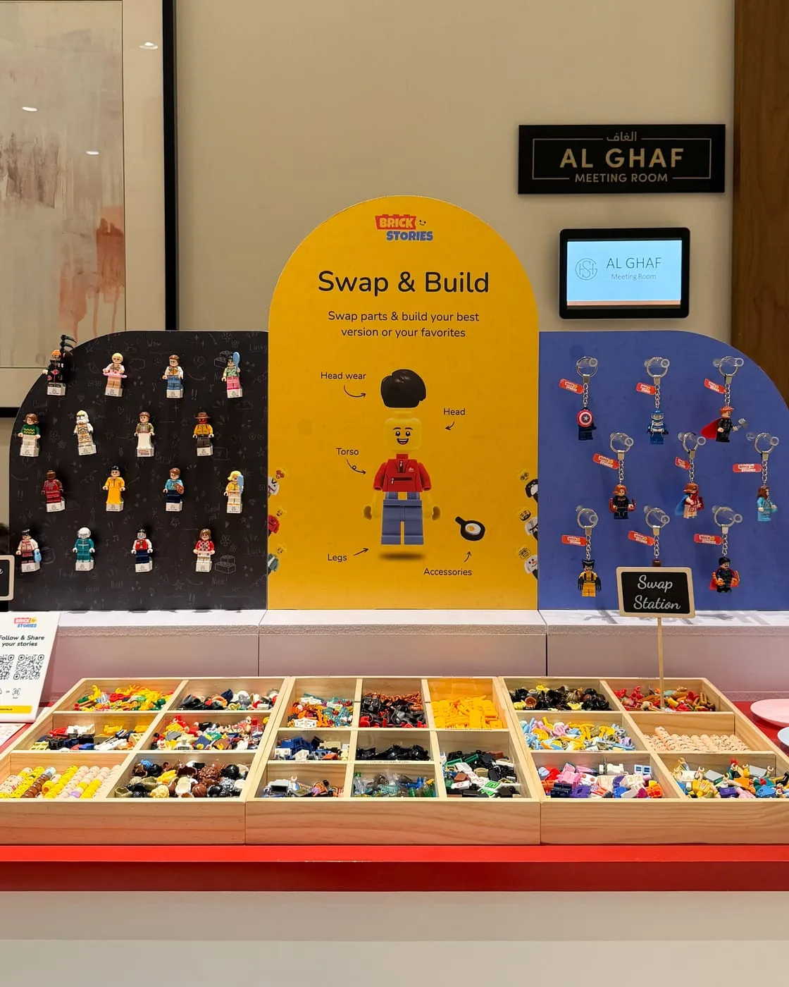 A Swap & Build station set up in a meeting room, with figure boards above trays of parts