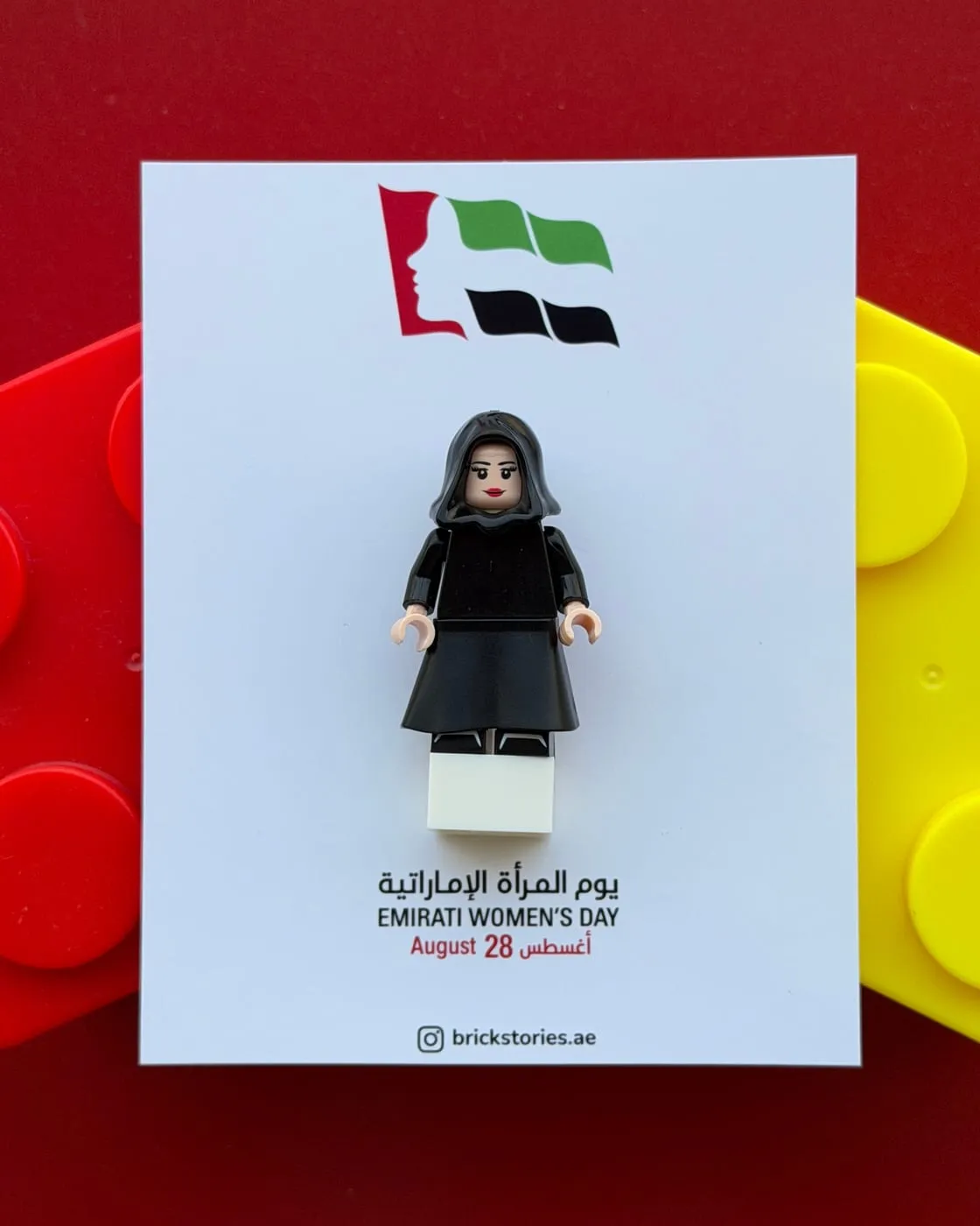 A mini figure in an abaya on an Emirati Women’s Day backing card